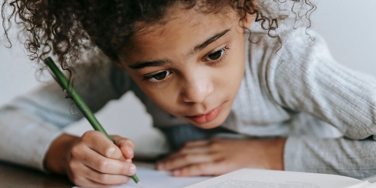 Niño practicando la escritura con un lápiz en un cuaderno