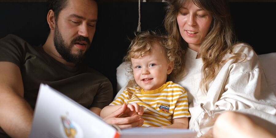 Familia leyendo junto a su hija en un ambiente cálido en casa